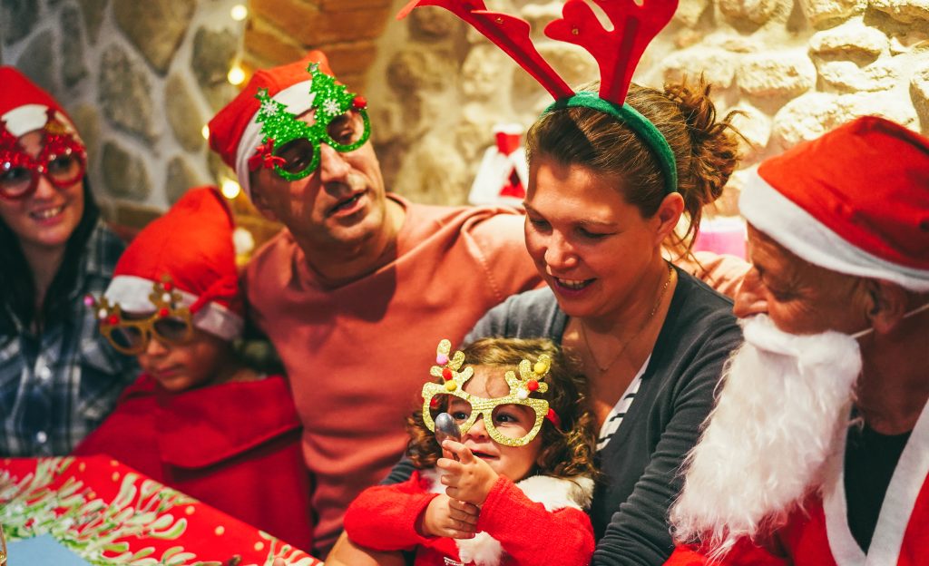 Happy family having fun at dinner during Christmas time - Focus on little girl hands