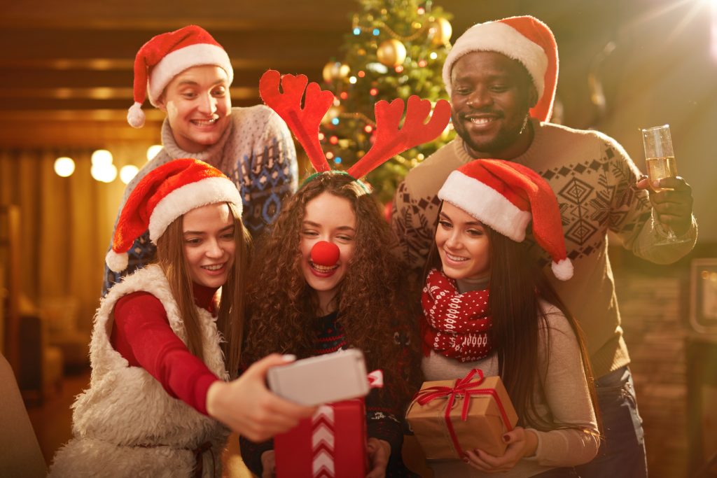 Cute friends photographing themselves at xmas party