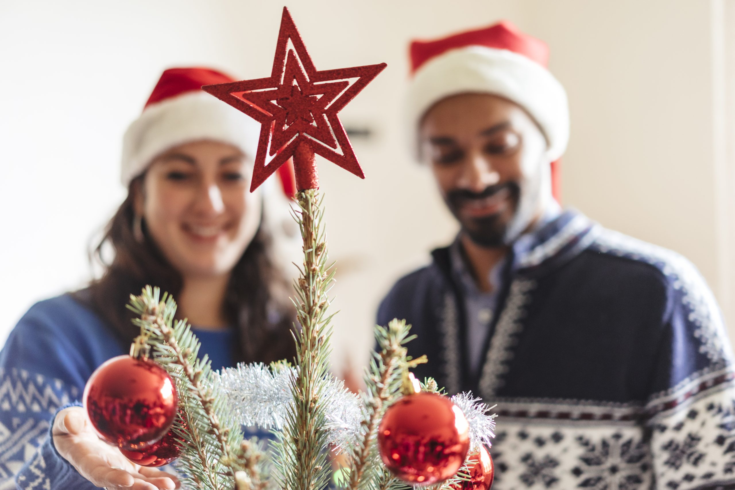 happy family with a young child decorating a christmas tree at home