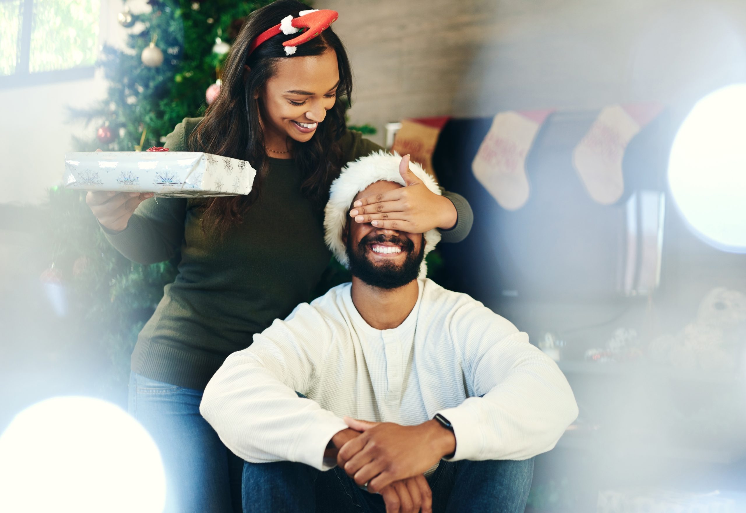 Shot of a happy young couple opening presents during Christmas at home.