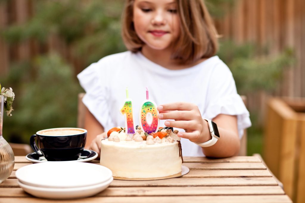 Girl putting candles on birthday cake