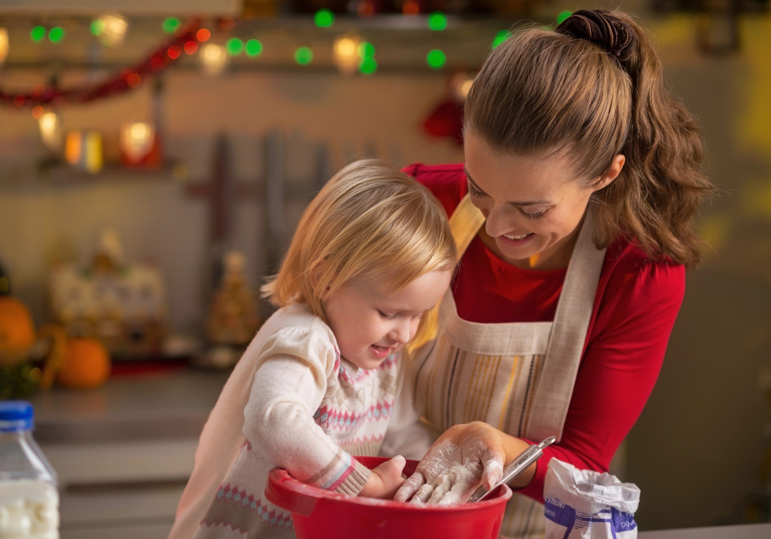 mom cooking at christmas with young daughter