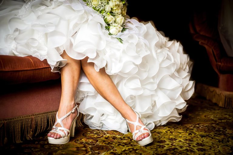 woman wearing beautiful white bridal dress with white high heels