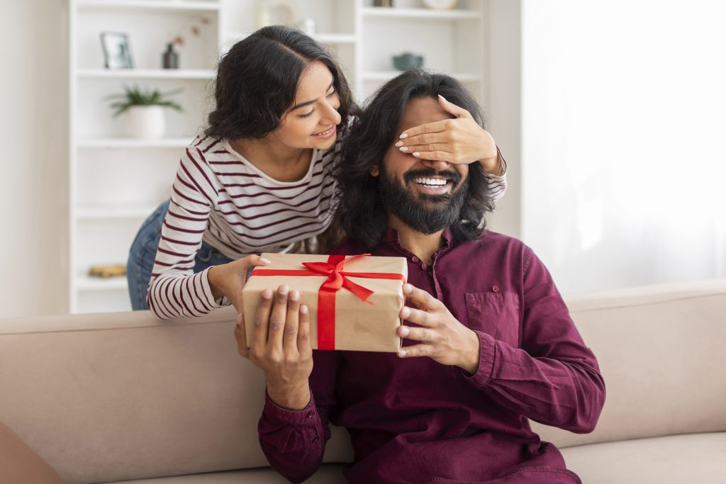 Cheerful indian couple celebrating birthday, anniversary at home