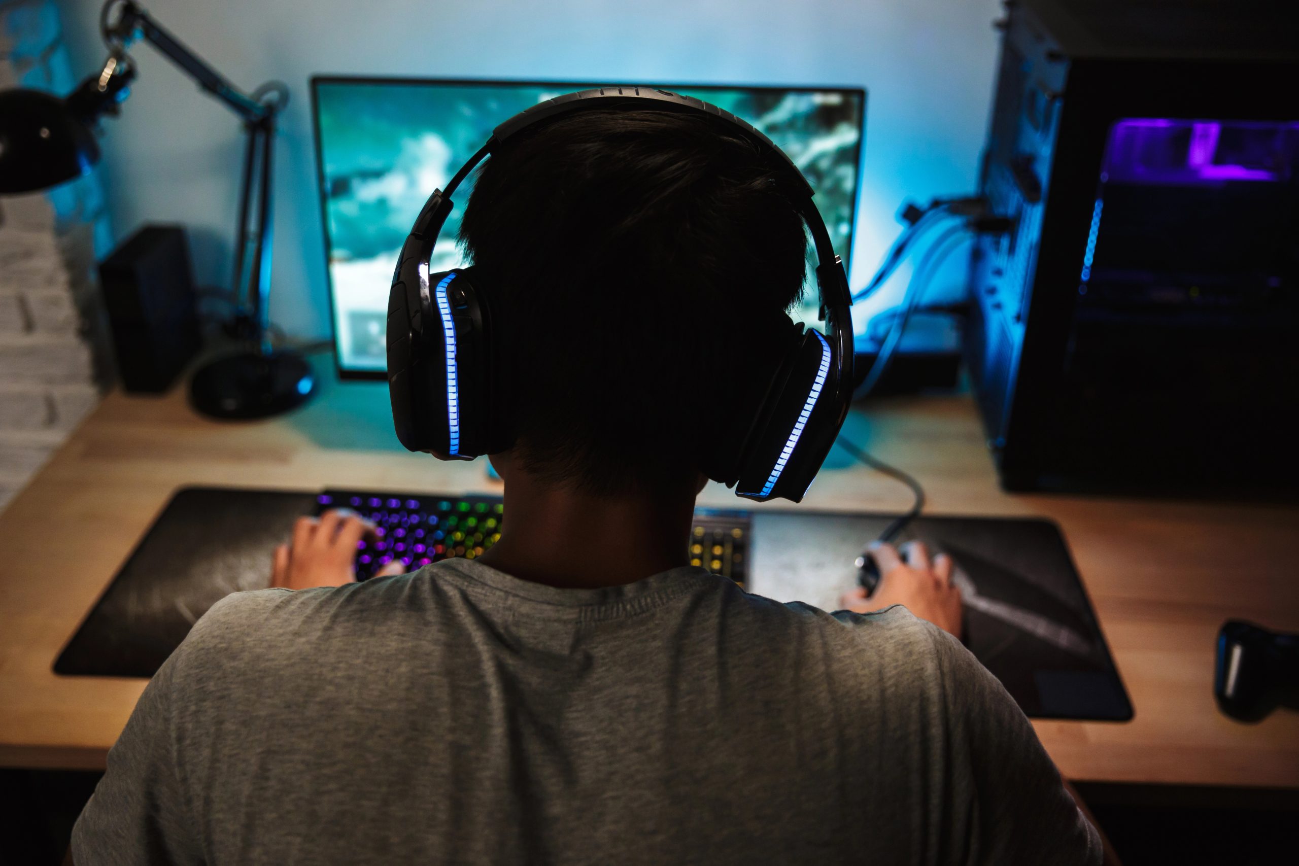 boy playing computer games with headset on