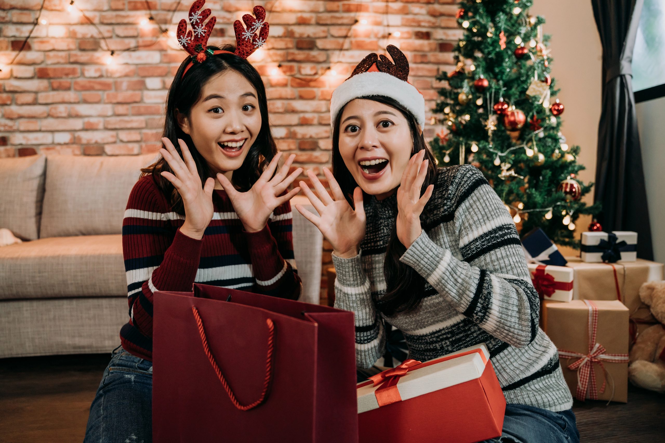 two friends opening christmas gift together