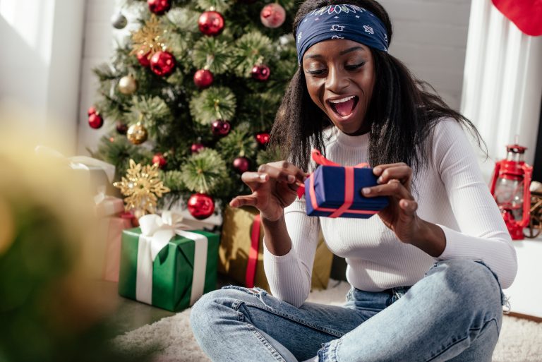 Happy young woman unwrapping christmas gift
