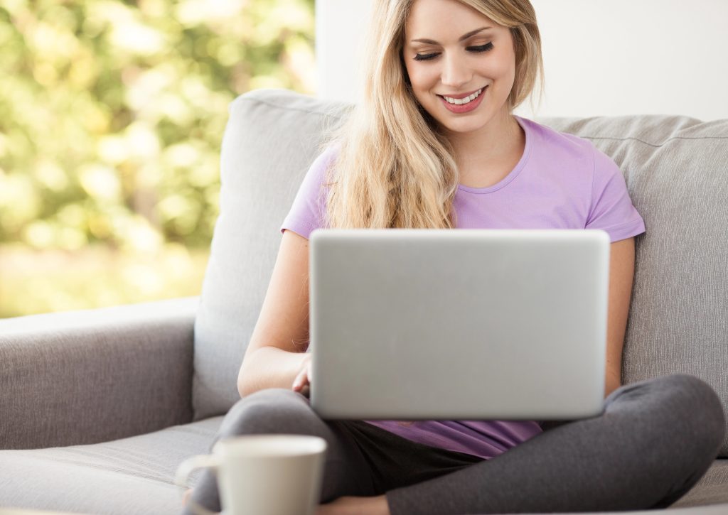 happy young woman reading on the computer