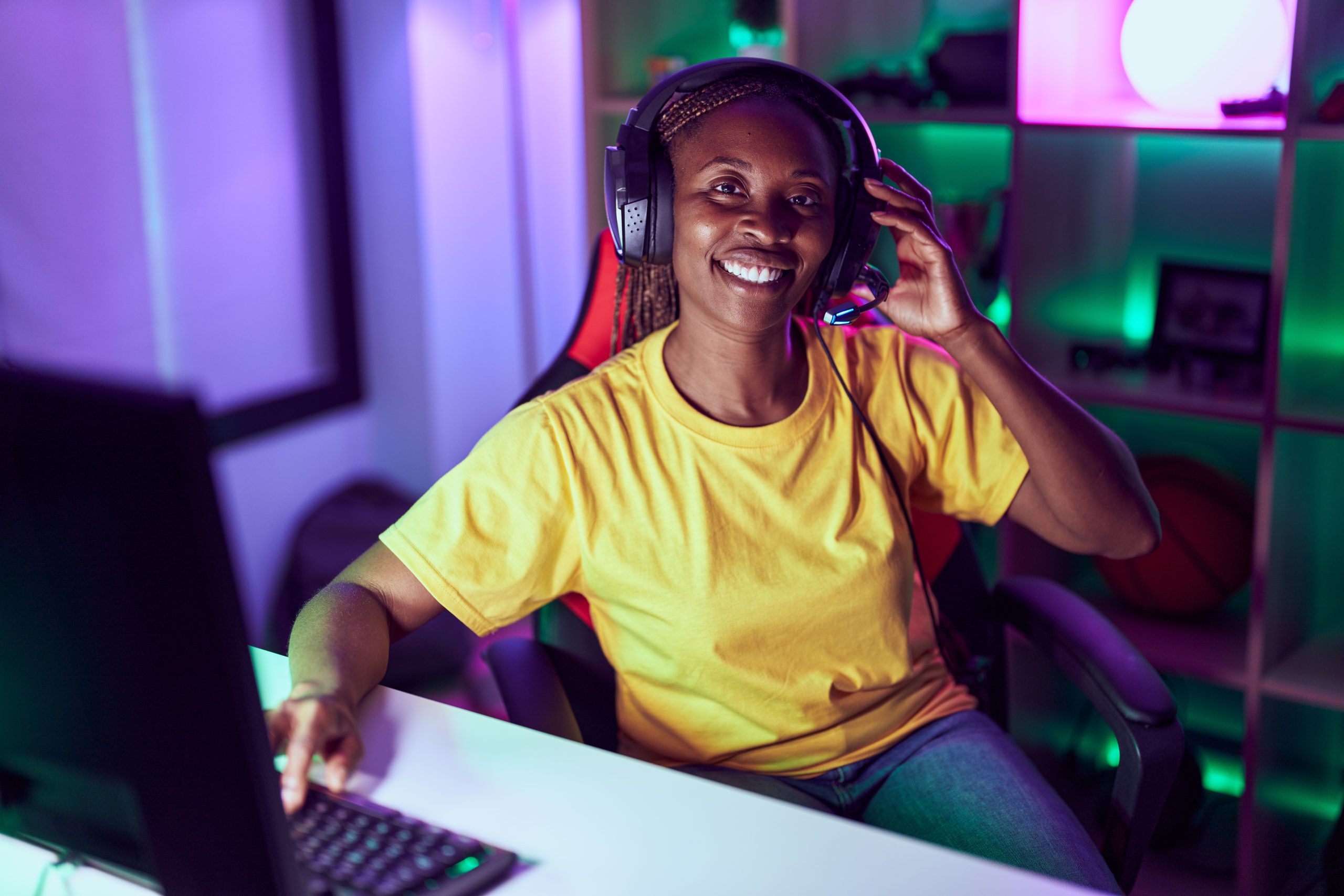 young african american girl playing computer games with headset on
