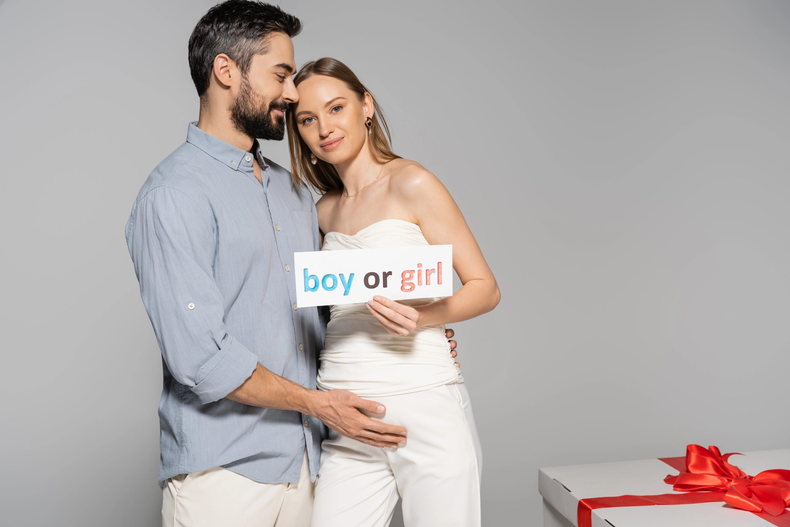 man and woman with boy or girl baby sign
