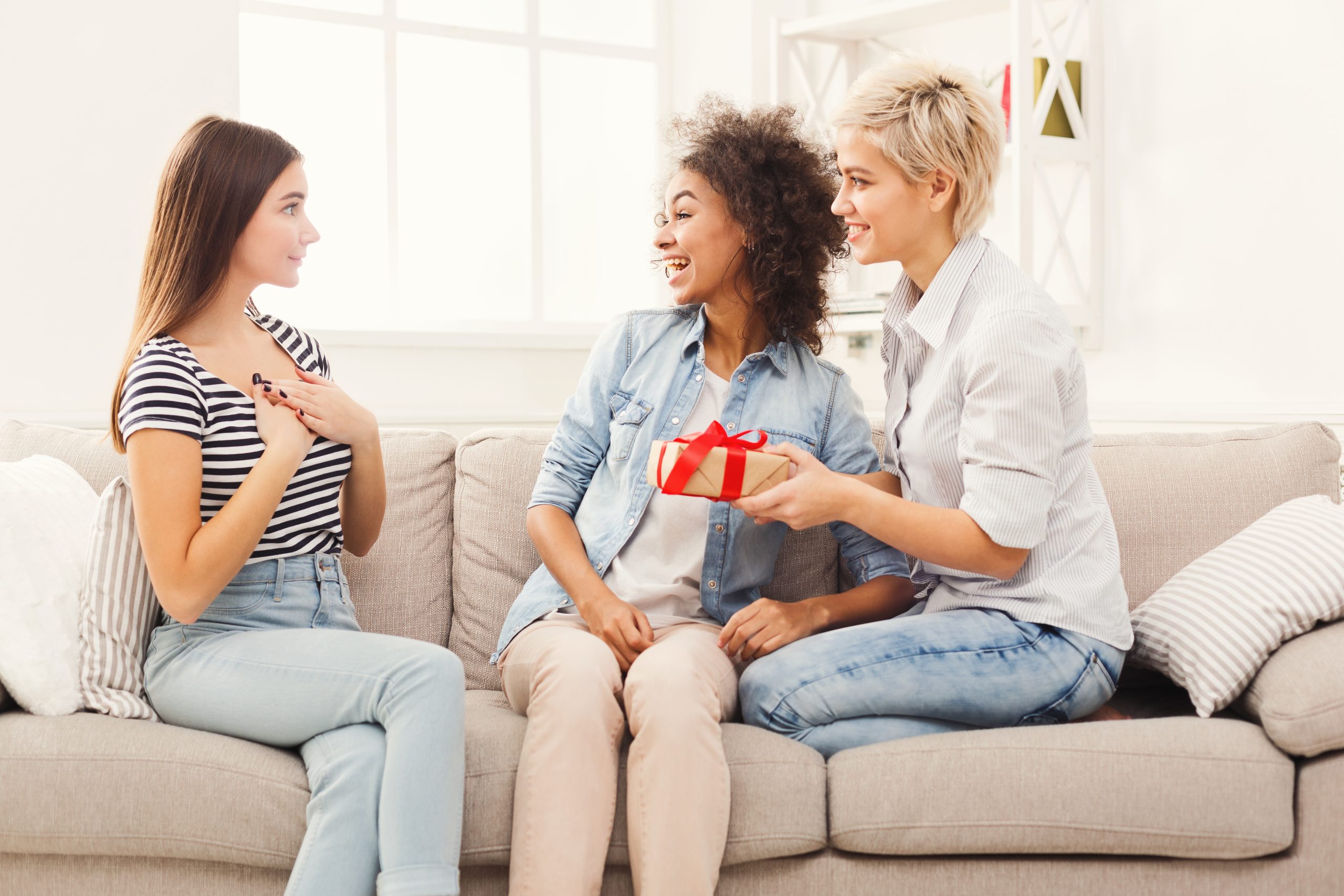 Excited woman getting gift from her friends
