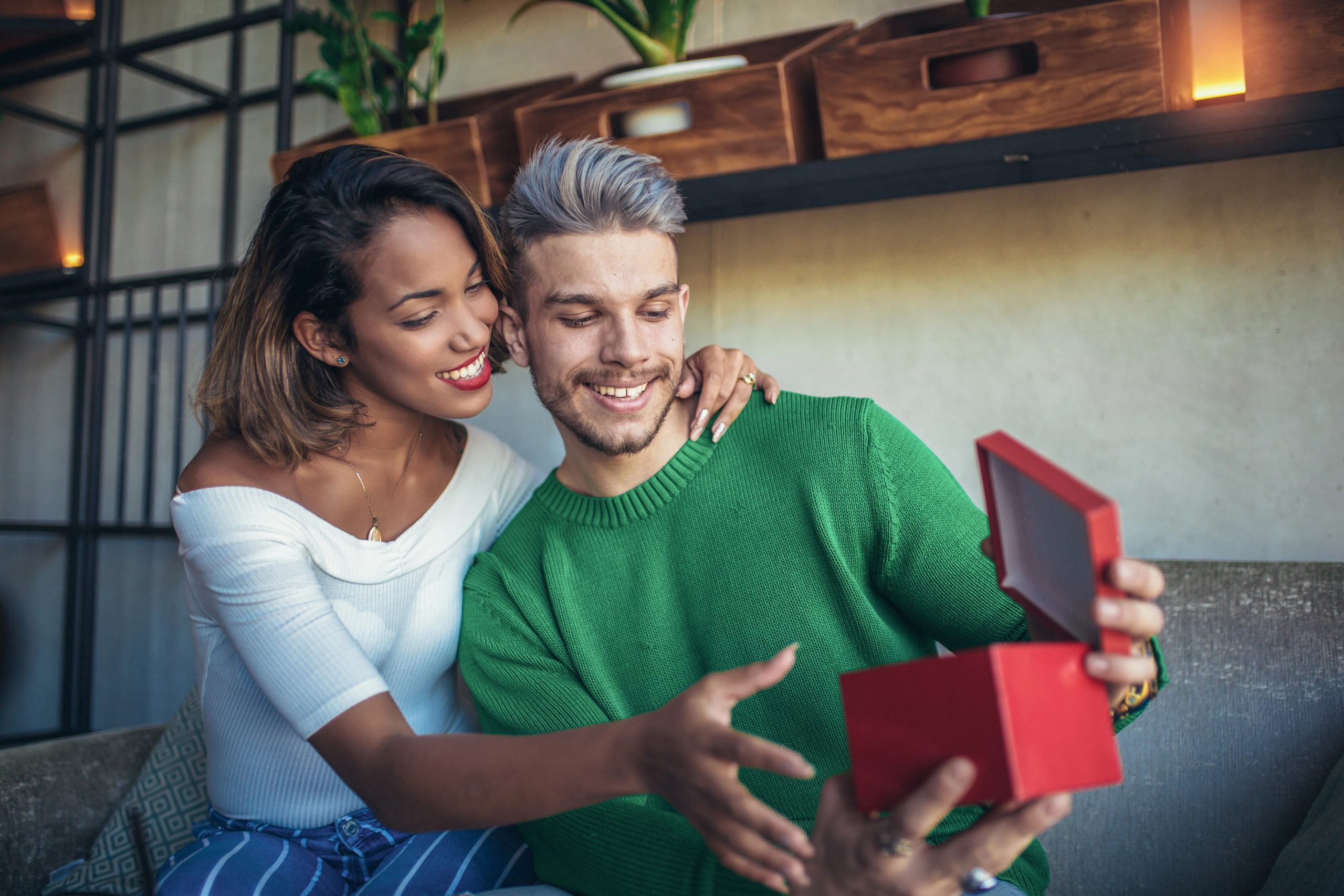 woman giving man coffee gift at cafe