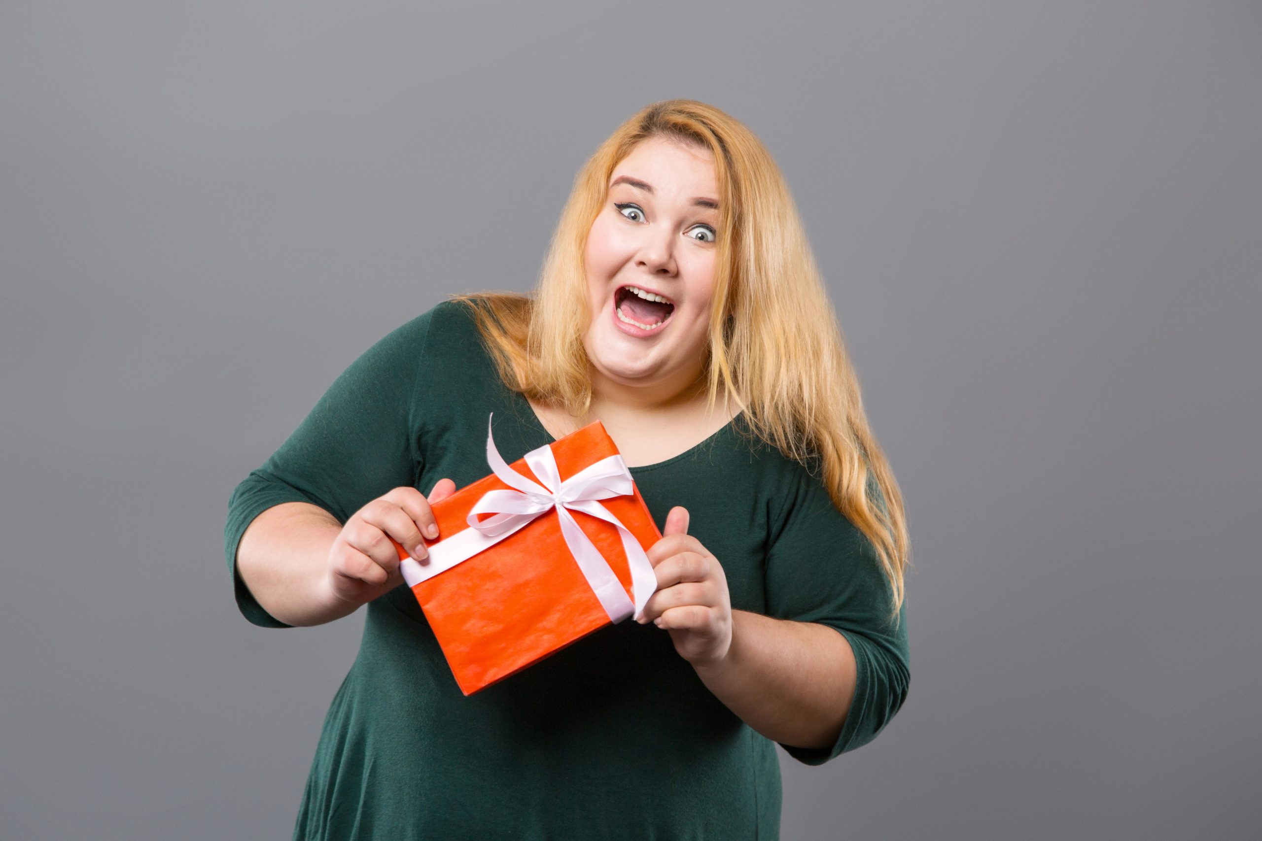 funny woman laughing with gift in hand