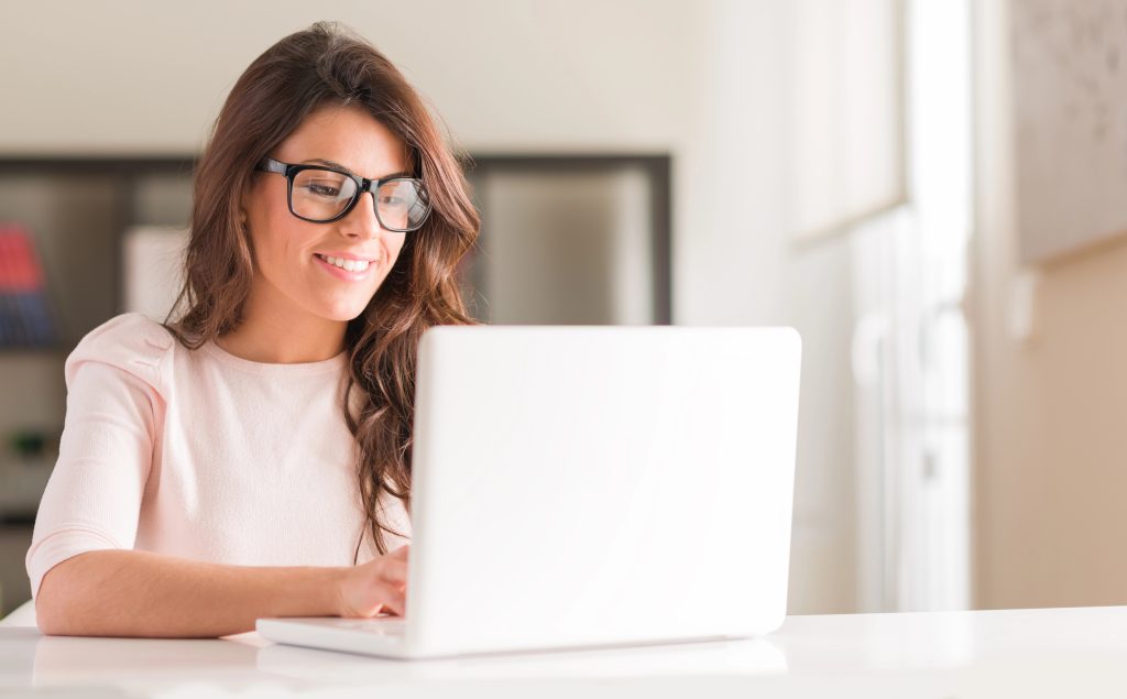 woman working on gift registry on computer smiling