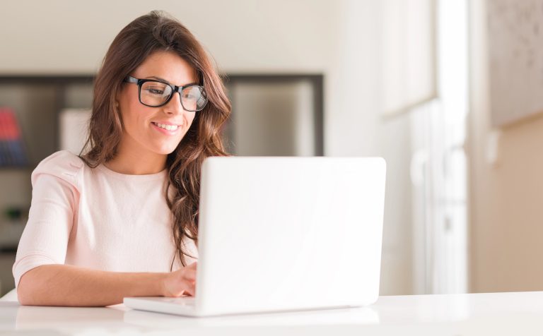 woman working on gift registry on computer smiling