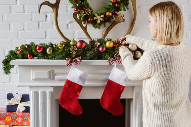 woman adding gifts to christmas stockings