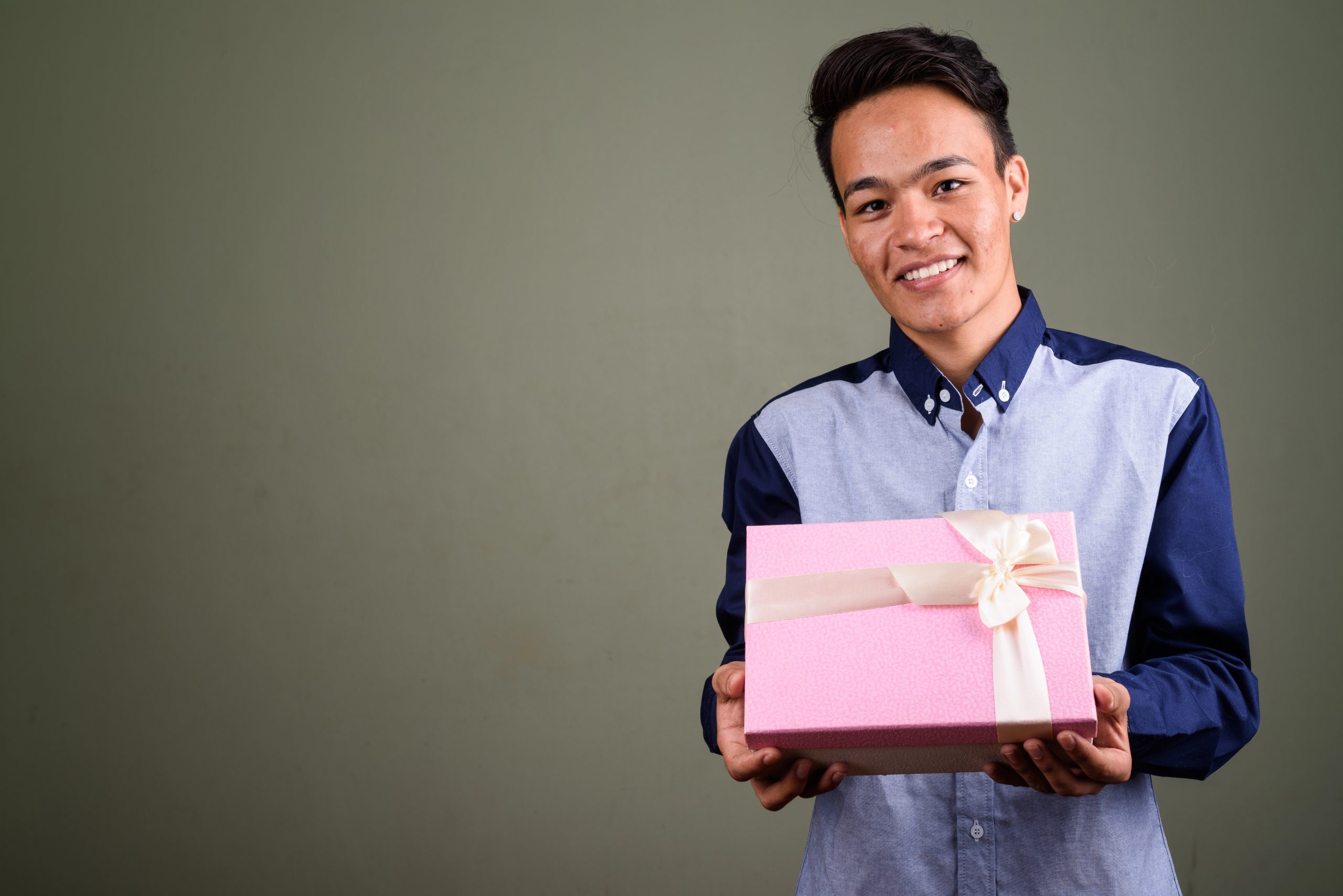 happy teenage guy smiling with gift