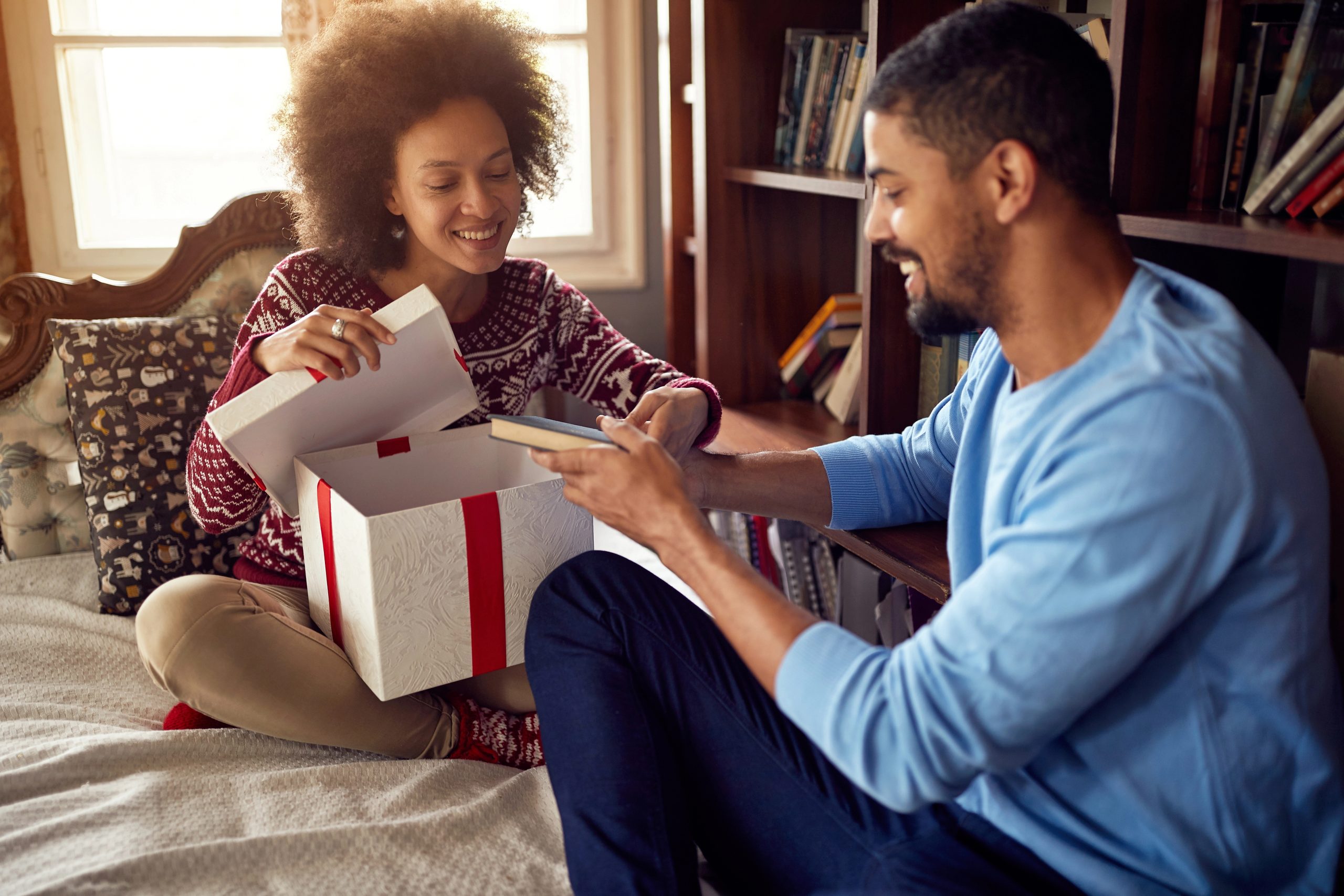 man and woman opening gifts together