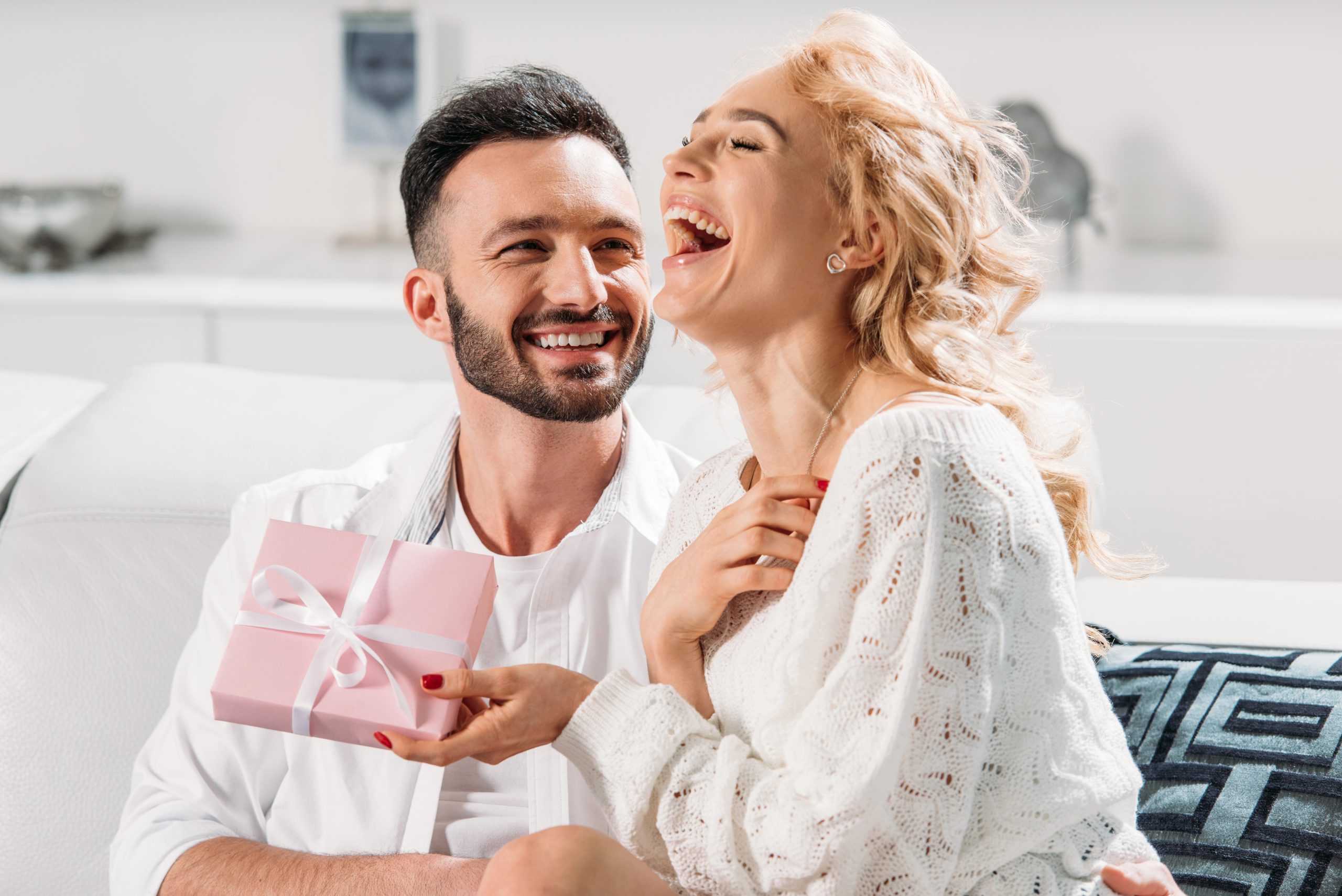 woman laughing smiling with gift from boyfriend