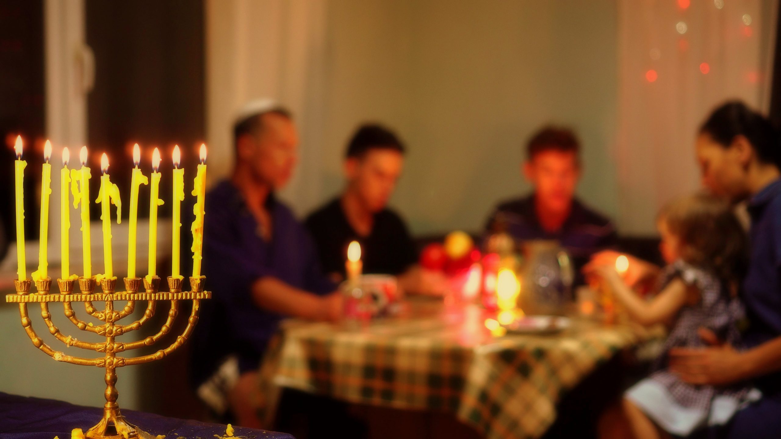 jewish family having dinner during hannukah