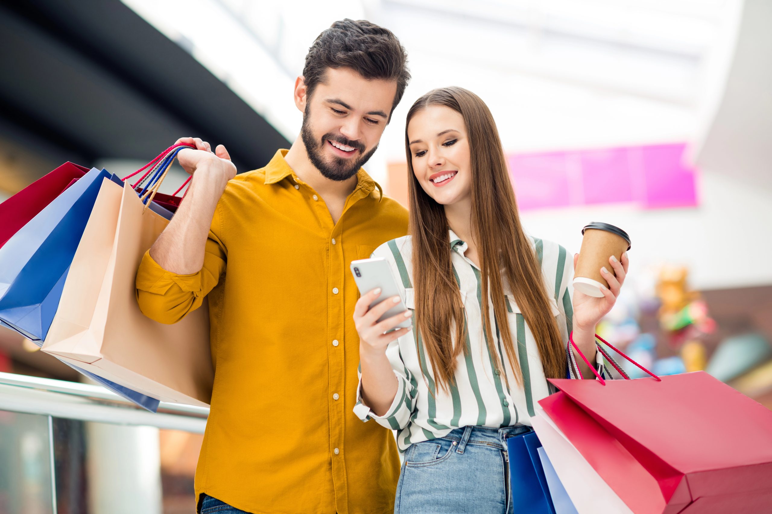 man and woman shopping with gift list on phone