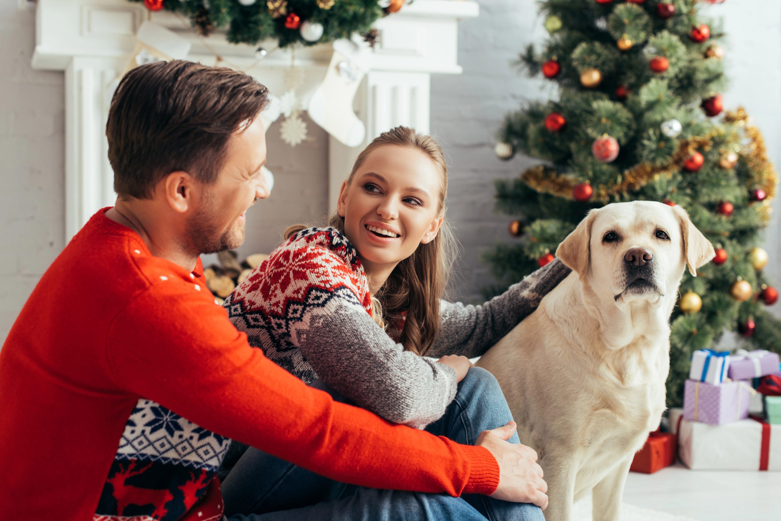 man and woman happy at christmas with dog