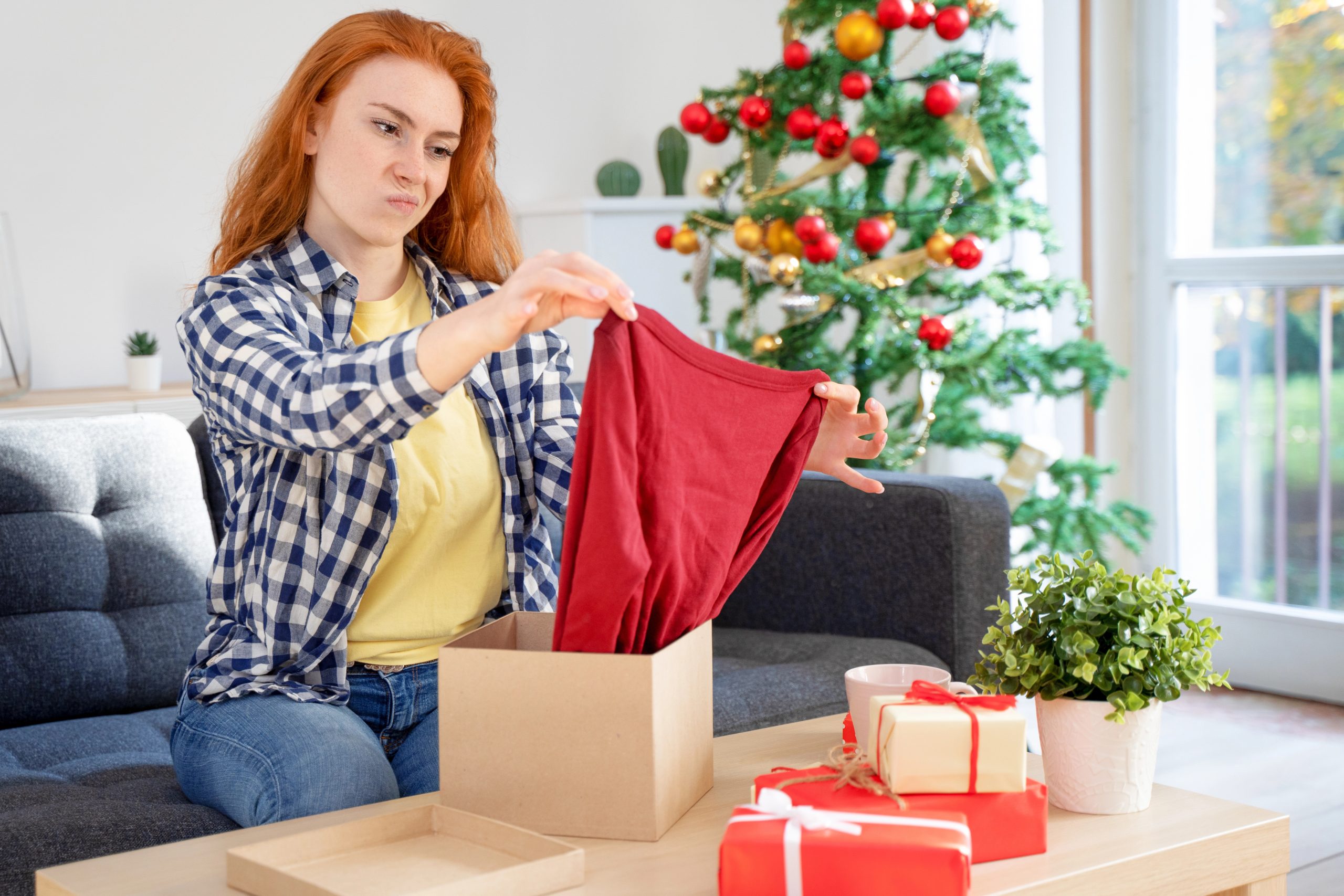 woman with confused face opening gift