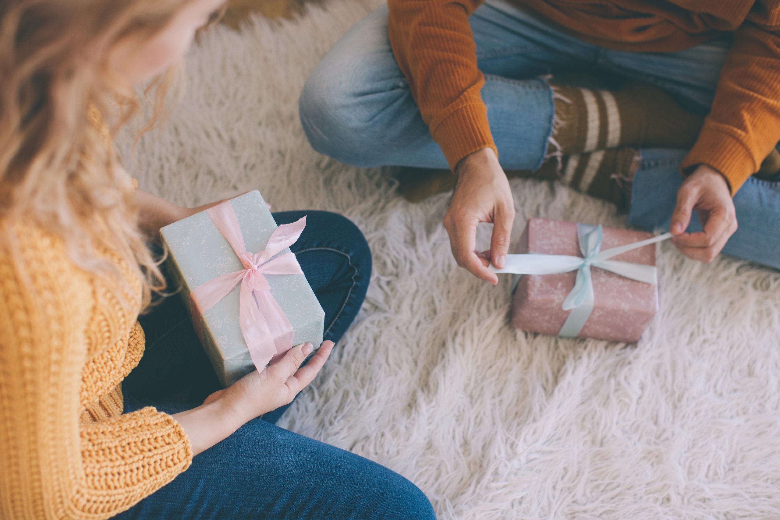 two friends opening gifts on floor