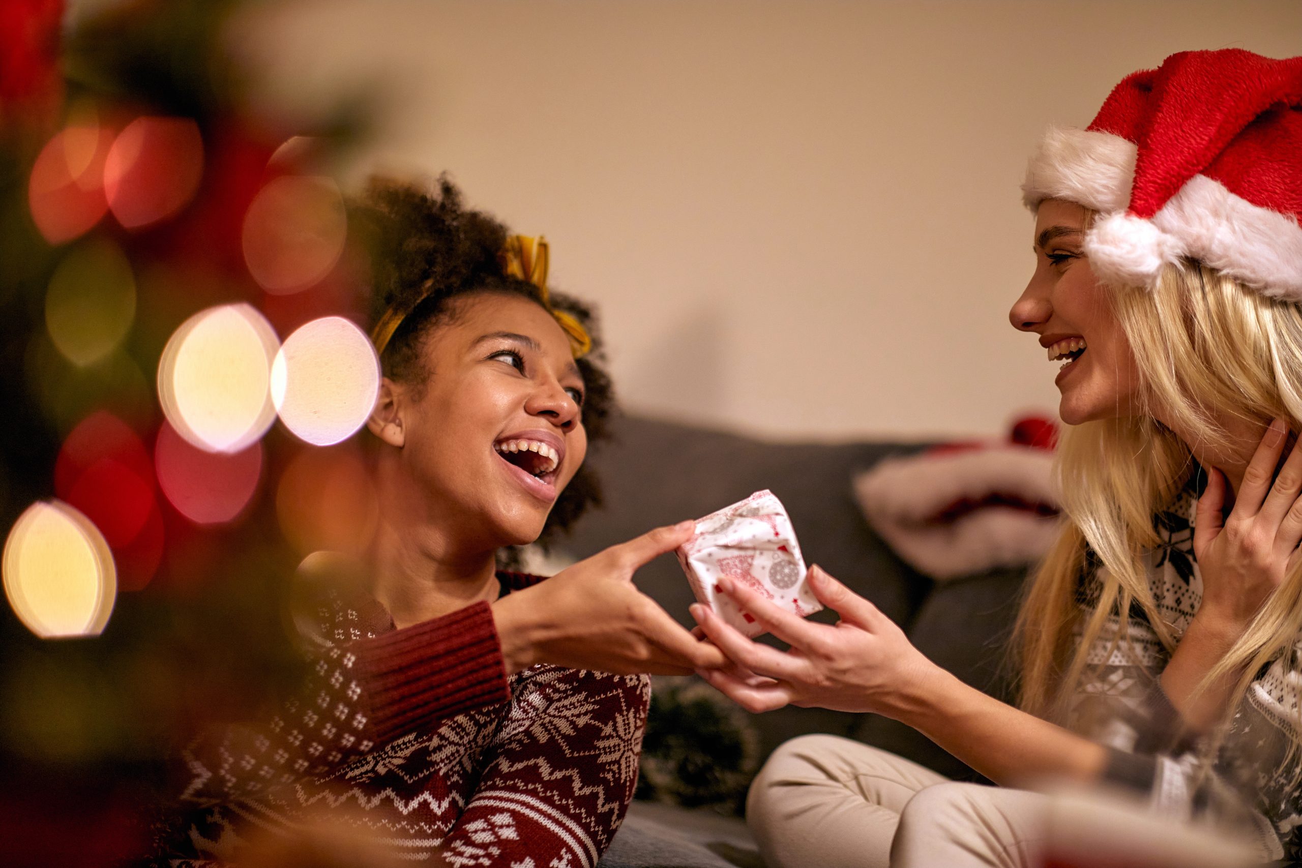 young woman handing gift to friend