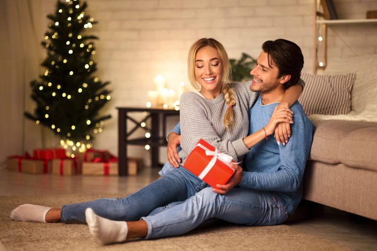 couple hugging at christmas with gift