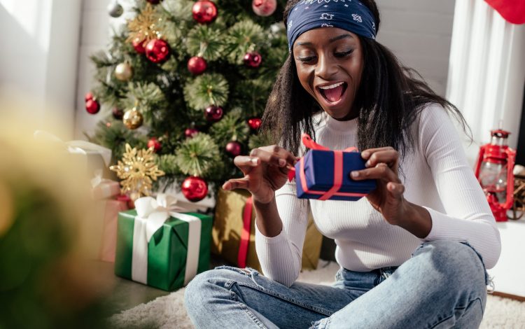 Happy young woman unwrapping christmas gift