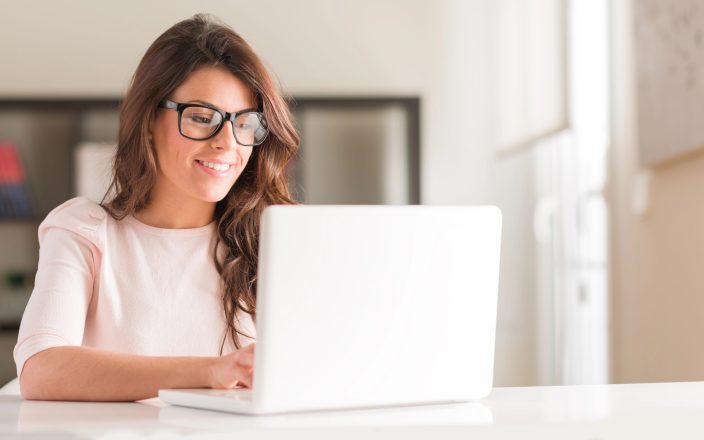 woman working on gift registry on computer smiling
