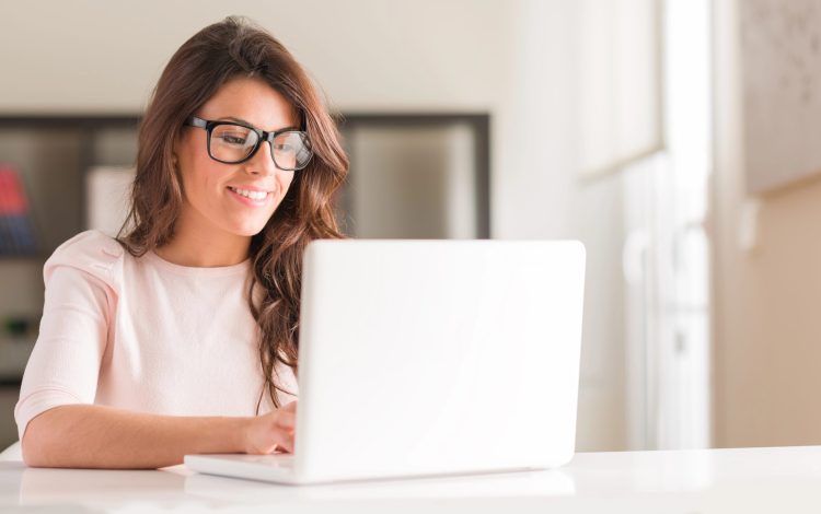woman working on gift registry on computer smiling