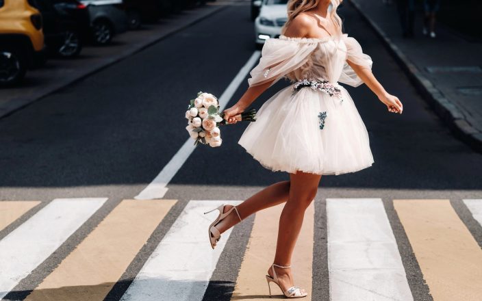 bride crossing street in short wedding dress