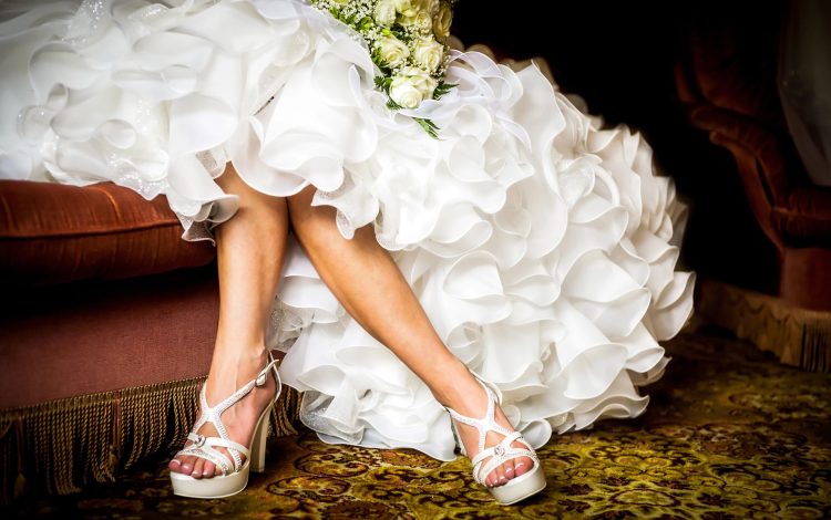 woman wearing beautiful white bridal dress with white high heels