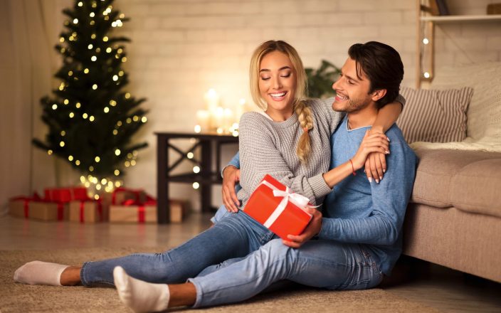 couple hugging at christmas with gift