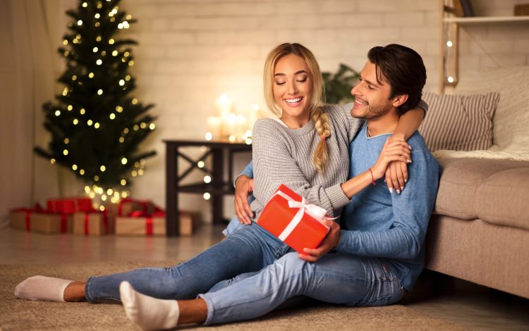couple hugging at christmas with gift