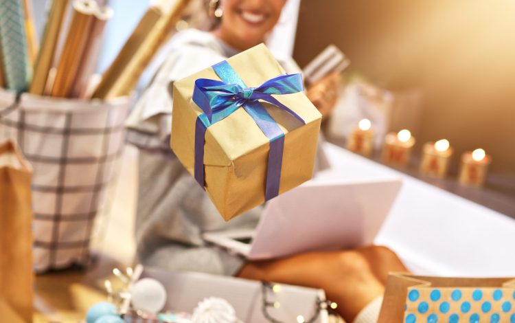 Picture showing adult woman at home wrapping Christmas presents