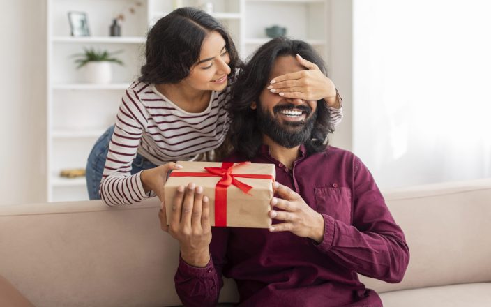 Cheerful indian couple celebrating birthday, anniversary at home
