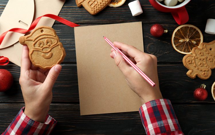 Concept of writing wishlist on wooden table, top view