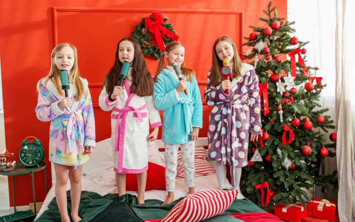 Merry Christmas and Happy Holidays. Group of children having fun at pajama party in Christmas room. Cozy home