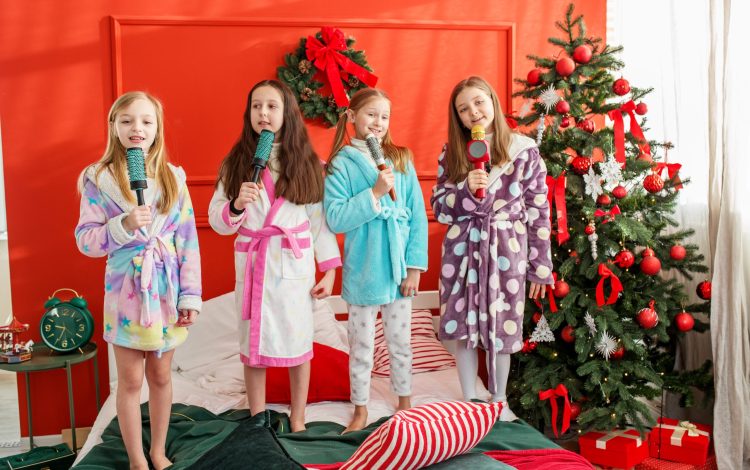 Merry Christmas and Happy Holidays. Group of children having fun at pajama party in Christmas room. Cozy home