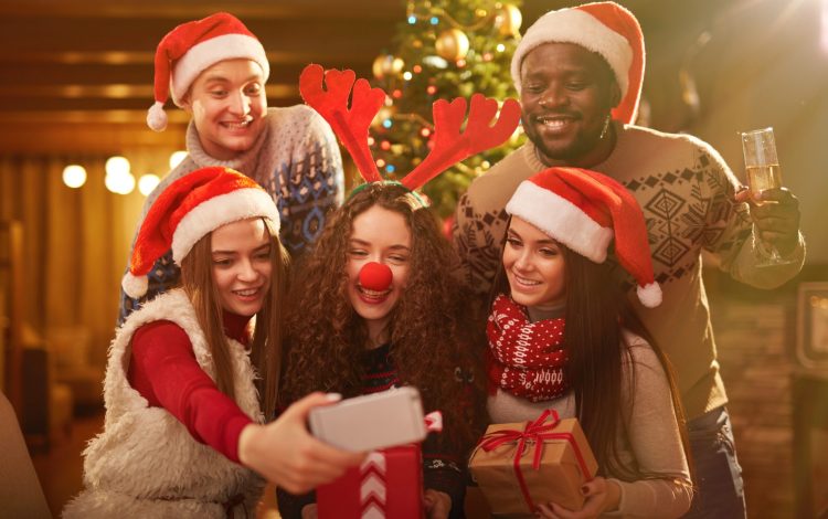 Cute friends photographing themselves at xmas party