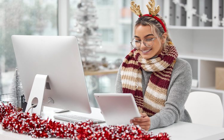 Tis the season. Shot of a young woman in the festive period working in a office